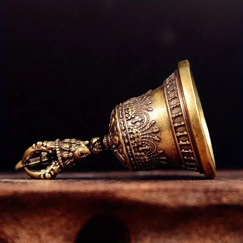 Clochette en bronze vintage Nesty - Vue de profil, posée sur du bois