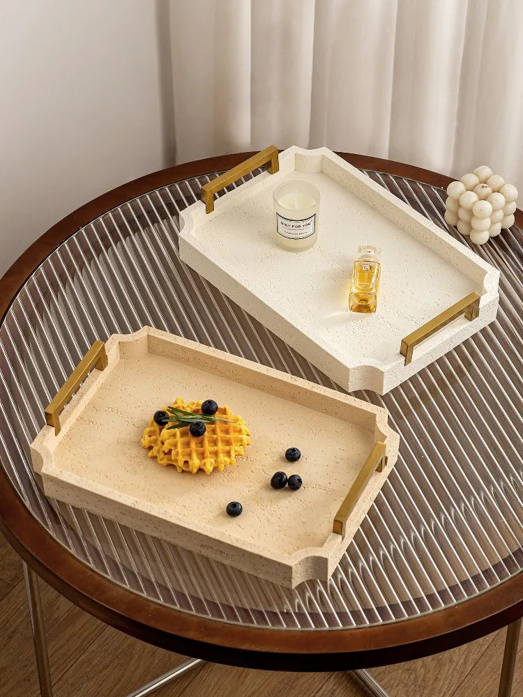 Duo de plateaux en travertin à poignées dorées, coloris blanc et beige, sur table ronde avec bougie et boule décorative - Nesty