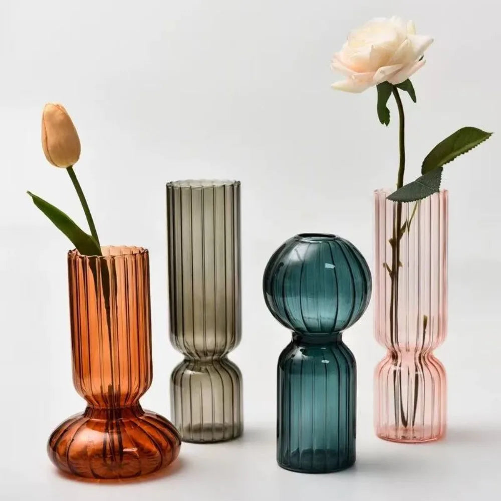 Vase en verre strié coloré, esprit scandinave Nesty, quatre coloris côtelés (orange, gris, bleu canard en forme boule, rose), chacun garni d'une fleur