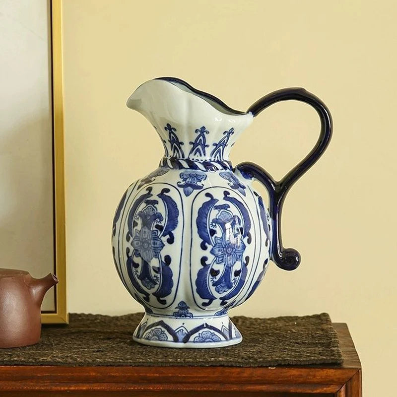 Vase en porcelaine bleu et blanc, motif ancien Nesty, pichet à motifs floraux et anse bleu foncé, posé sur un meuble en bois