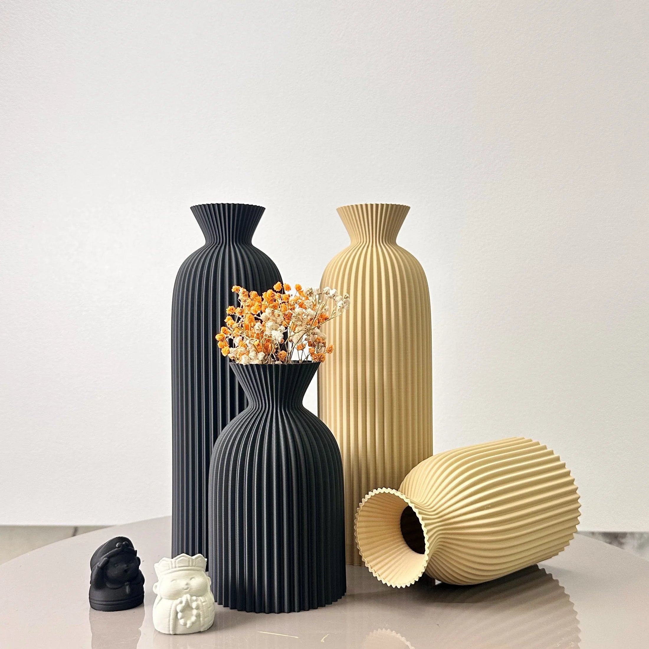 Duo de vases à motif ondulé pour fleurs séchées Nesty, quatre vases côtelés noirs et beiges, un petit noir garni de fleurs séchées orange et blanches