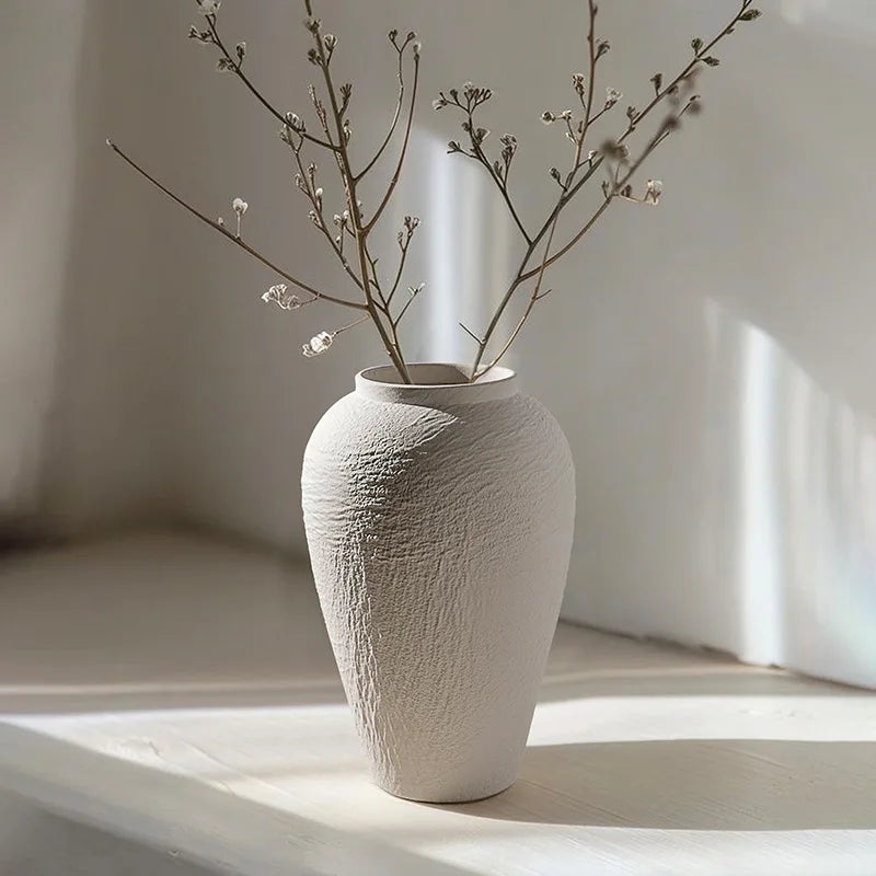 Vase en porcelaine texturée effet pierre, Jingdezhen Nesty, format texturé garni de brindilles à petites fleurs blanches, en contre-jour