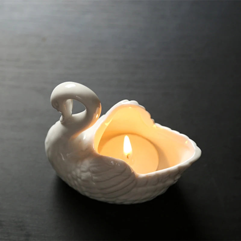Photophore cygne en céramique Nesty - Photophore blanc en forme de cygne avec bougie chauffe-plat allumée à l'intérieur, fond sombre