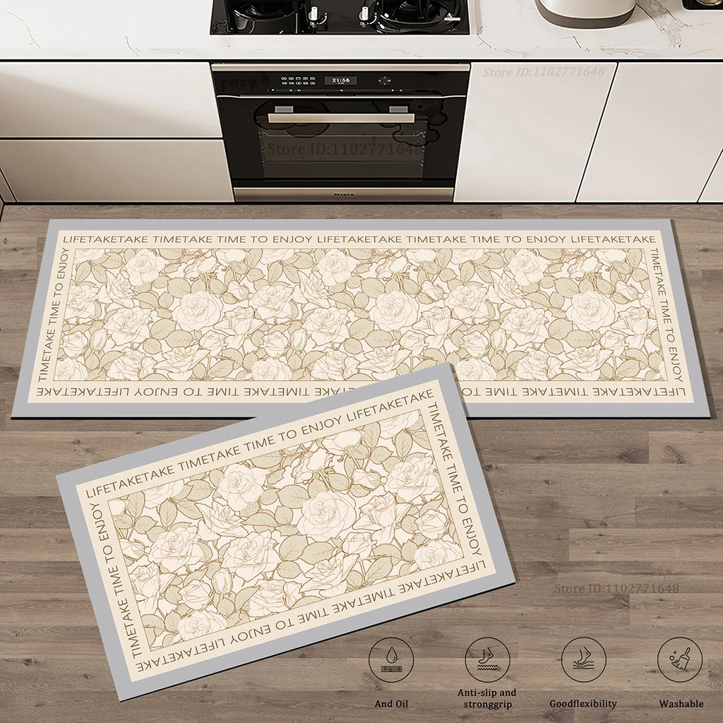 Set de deux tapis de cuisine à motif de roses en dégradé de tons beige et gris avec bordure à inscription, posés dans une cuisine.