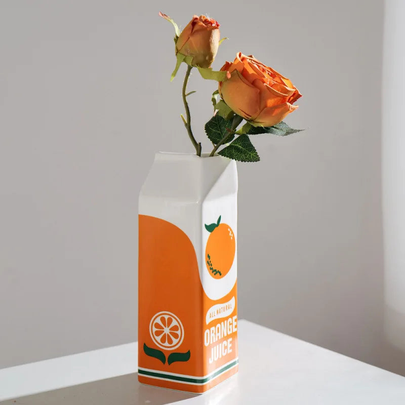 Vase en céramique forme fruit, orange décorative Nesty, même vase en forme de brique "Orange Juice" garni de roses oranges, sur table blanche
