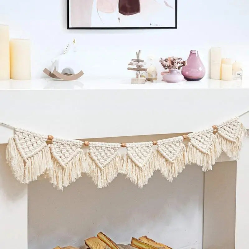 Tenture macramé à franges à tissage bohème Nesty, guirlande de fanions à franges accrochée sous un manteau de cheminée blanc avec bougies et vases