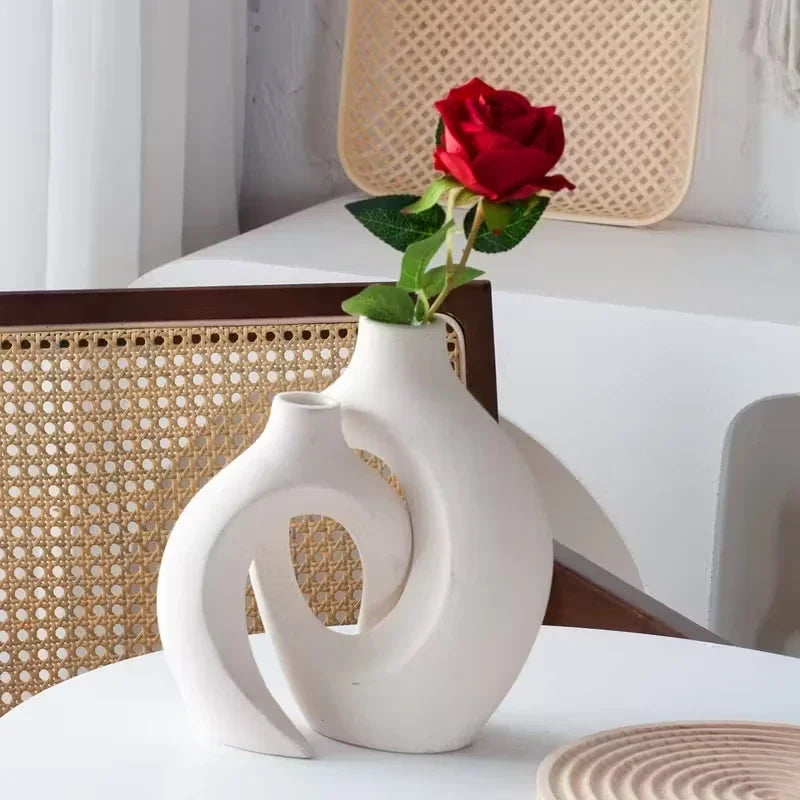 Set de vases blancs en plastique — style européen - Nesty - Vase double anneau blanc mat avec une rose rouge, posé sur une chaise en cannage