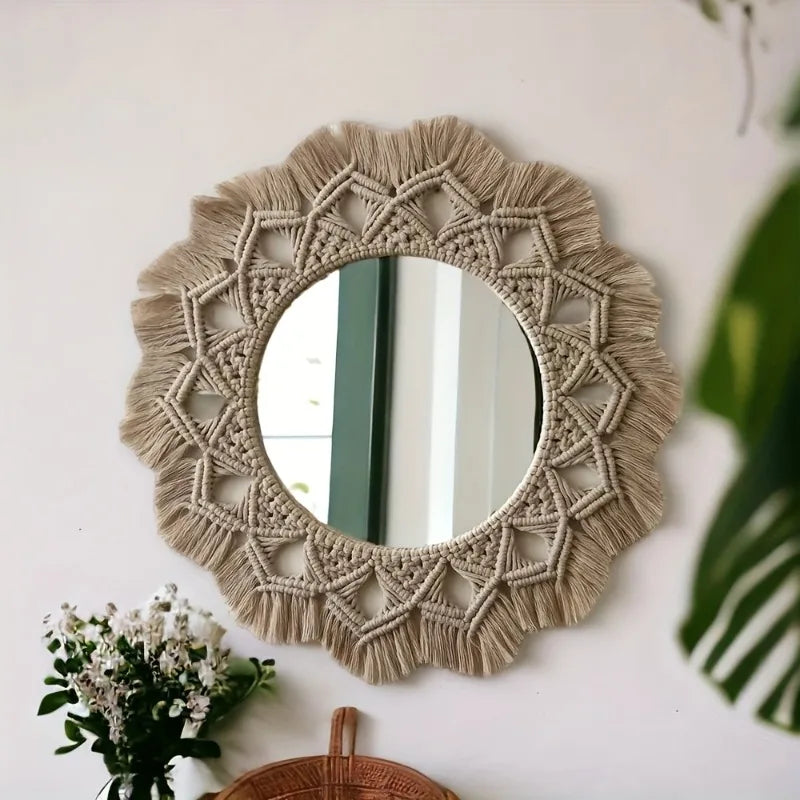 Miroir mural rond en macramé façon mandala, motif triangulaire tressé et franges, avec bouquet de fleurs blanches en premier plan - Nesty