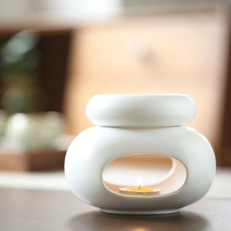 Brûle-parfum en céramique grande capacité Nesty - Modèle blanc galbe organique, bougie allumée, posé sur console
