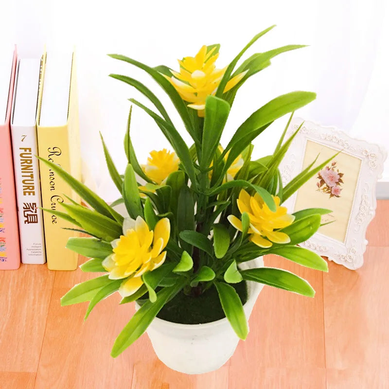 Pot de fleurs artificielles lotus Nesty - Coloris jaune, posé près de livres