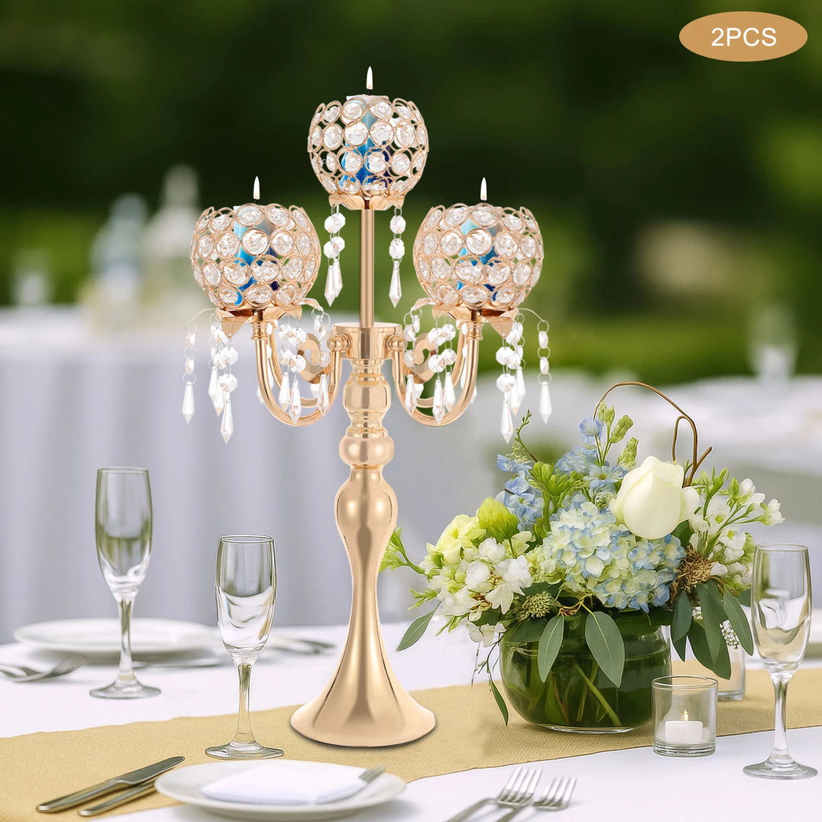 Bougeoir en verre Nesty - Candélabre doré en extérieur sur nappe blanche avec fleurs bleues et blanches et verres à champagne, lot de 2 pièces