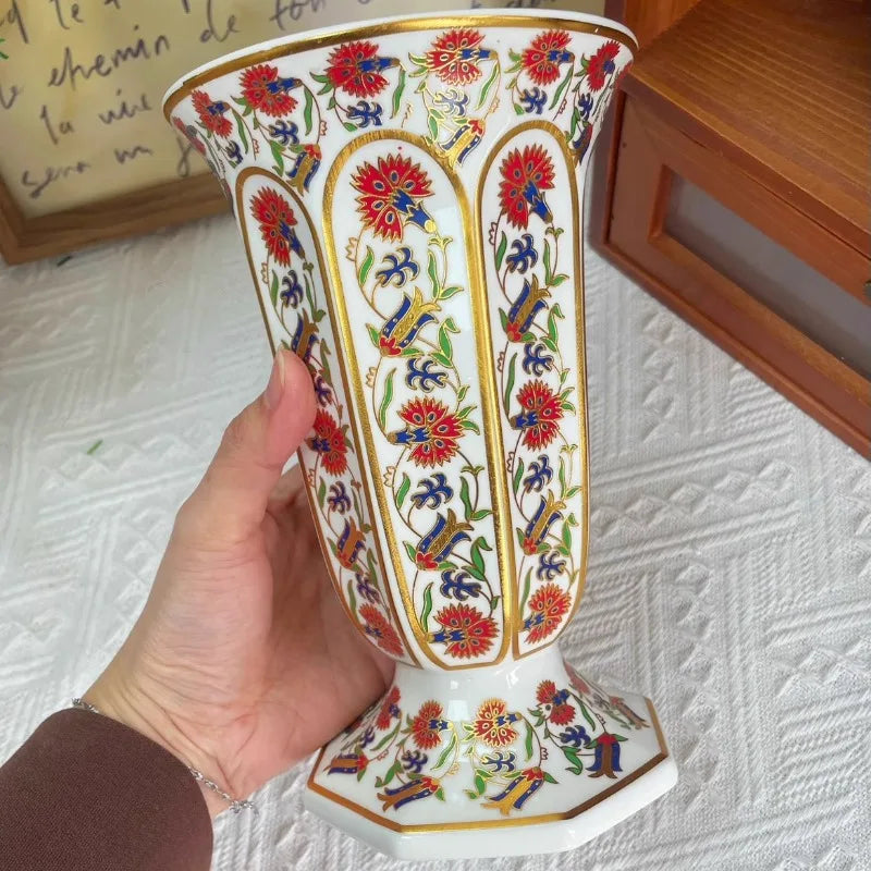Vase en porcelaine, petit format sobre pour bureau Nesty, même vase à motifs floraux rouges et dorés tenu à la main, montrant le col évasé de profil
