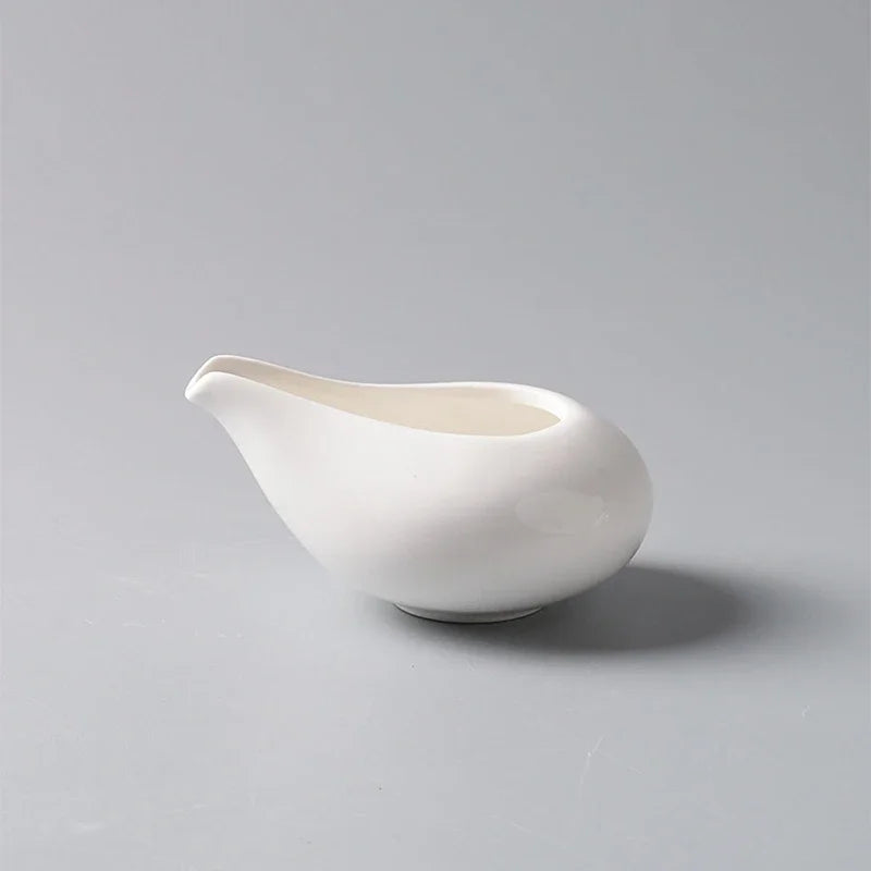 Petit pot à lait en céramique blanche avec anse Nesty, vue de profil complet sur fond gris