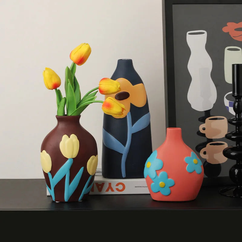 Vase céramique émaillé teintes Morandi, style nordique - Nesty - Trois vases peints à motifs floraux, coloris marron à tulipes, bleu marine à fleur orange et corail à fleurs bleues, sur un meuble sombre