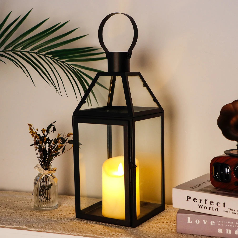 Lanterne suspendue en verre et métal noir Nesty - Bougie LED allumée, sur étagère avec livres et plante verte