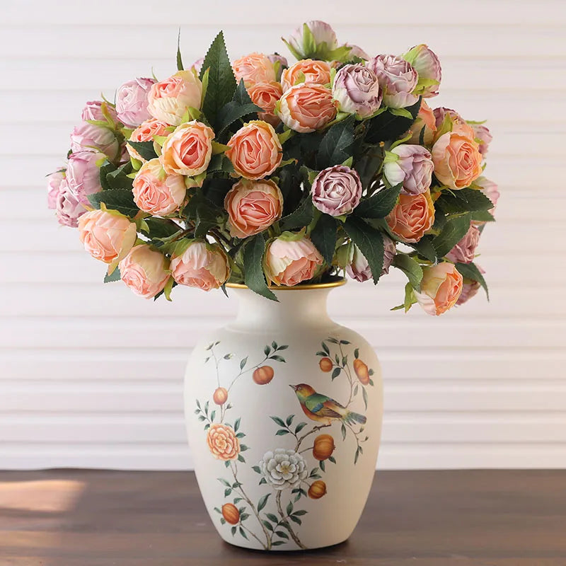 Vase en céramique de style classique, table à manger Nesty, vase garni d'un bouquet de roses roses et mauves artificielles, motif oiseau visible sur la panse