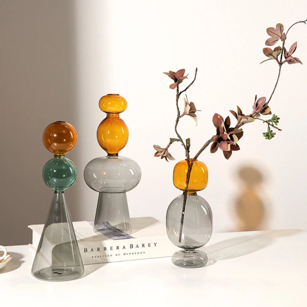 Vase en verre double paroi coloré, culture hydroponique - Nesty - Trois modèles empilés ambré-vert, ambré-gris et ambré-gris avec une branche de feuillage pourpre séché