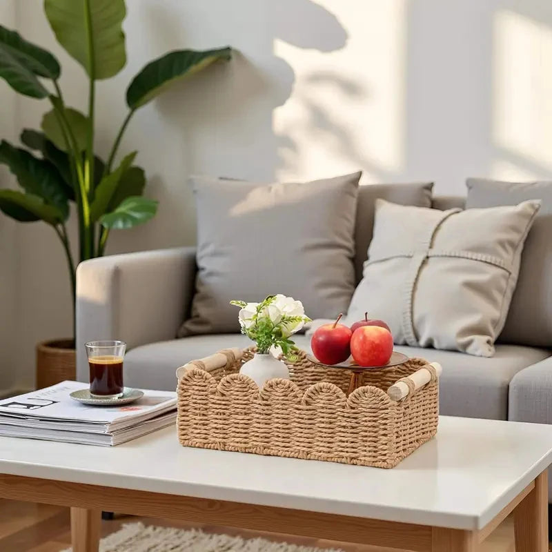 Panier de rangement en corde de papier tressée, bord festonné et poignées en bois Nesty, panier garni de pommes et d'un vase de fleurs sur une table basse, salon avec canapé