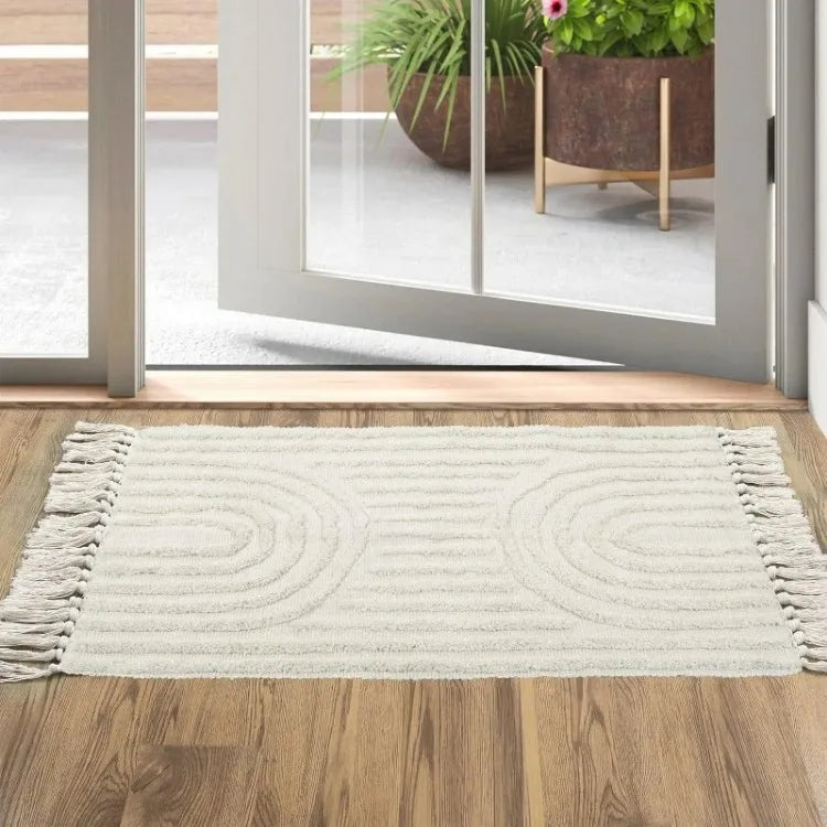 Tapis tufté en coton — tissé à la main - Nesty, variante à motif arches en relief, posée à l'entrée devant une baie vitrée coulissante