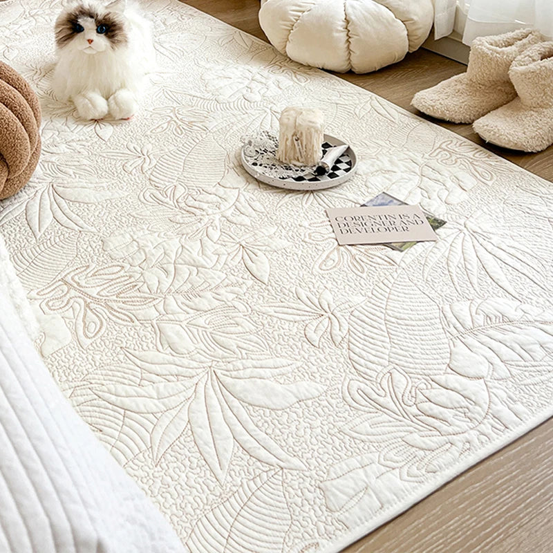 Tapis en coton lavé matelassé — coloris uni - Nesty, coloris écru matelassé à motif feuillage, avec un chat en peluche et une bougie