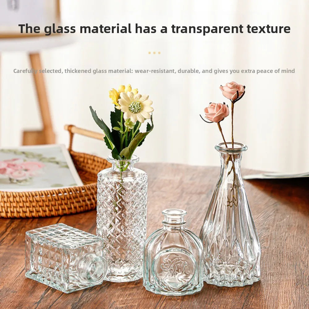 Set de mini vases en verre transparent, motif en relief - Nesty - Quatre modèles à motif quadrillé et cannelé sur une table en bois, avec une tulipe jaune, des roses roses et un panier en osier en arrière-plan