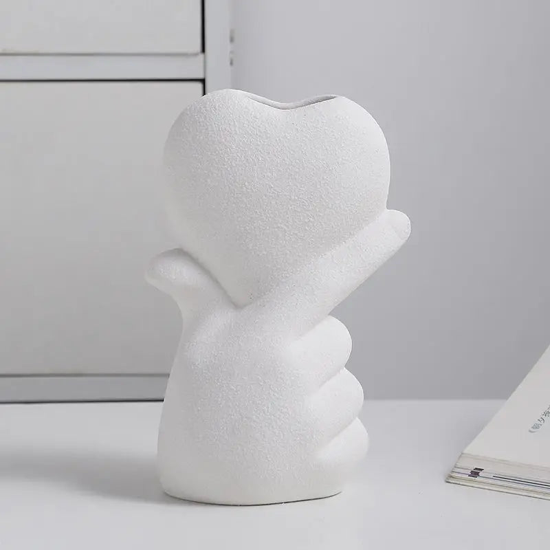 Vase en céramique forme cœur Nesty - Modèle blanc vue de face en gros plan, main tenant un cœur