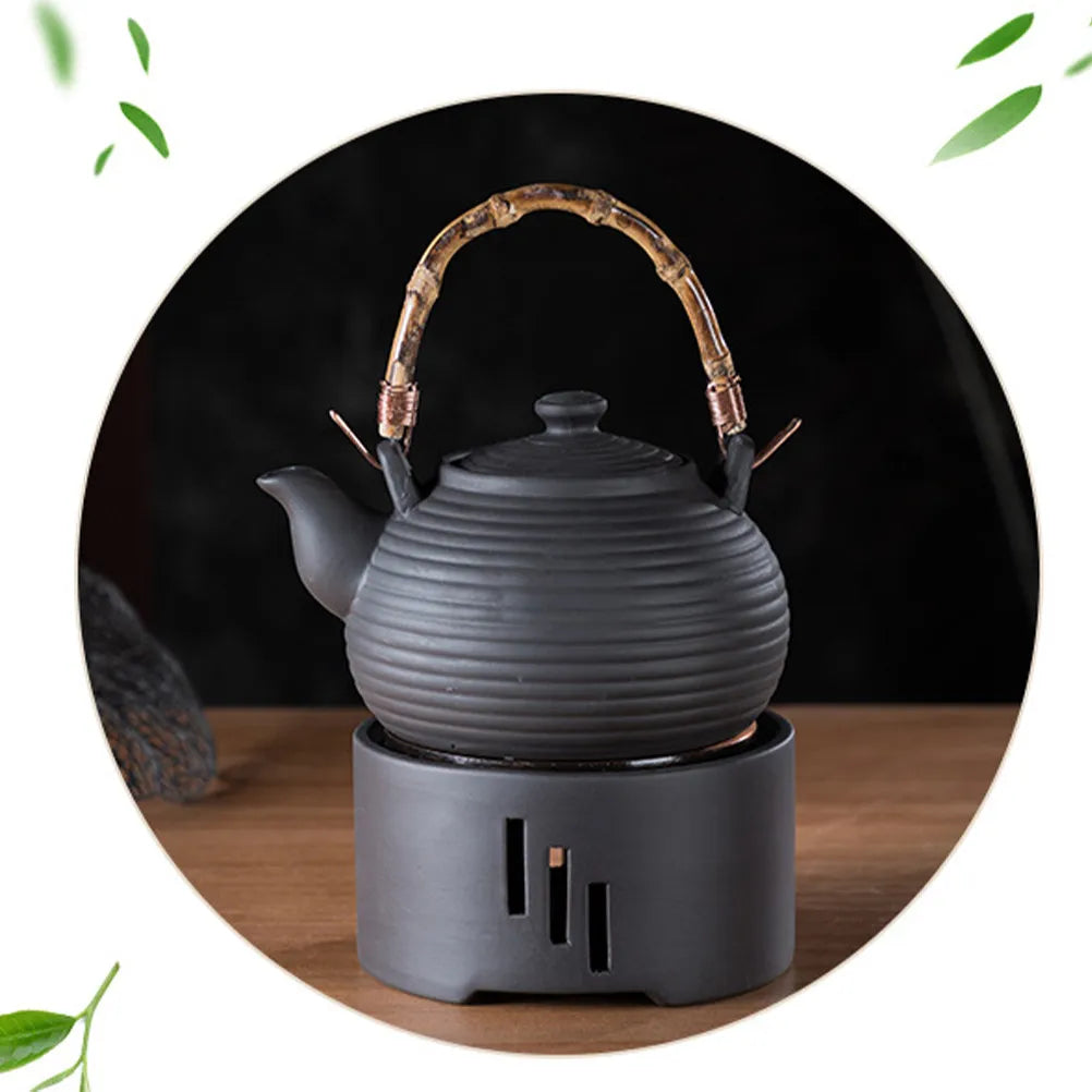 Chauffe-théière en céramique Nesty - Théière noire à anse en bambou posée sur le réchaud en céramique noire, fond sombre