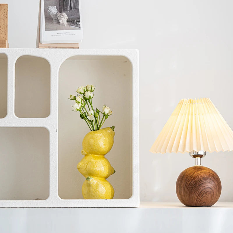 Coupelle-vase en céramique — fruits, fleurs ou bougie - Nesty - Vase citron avec petites roses blanches, dans une niche d'étagère blanche près d'une lampe en bois