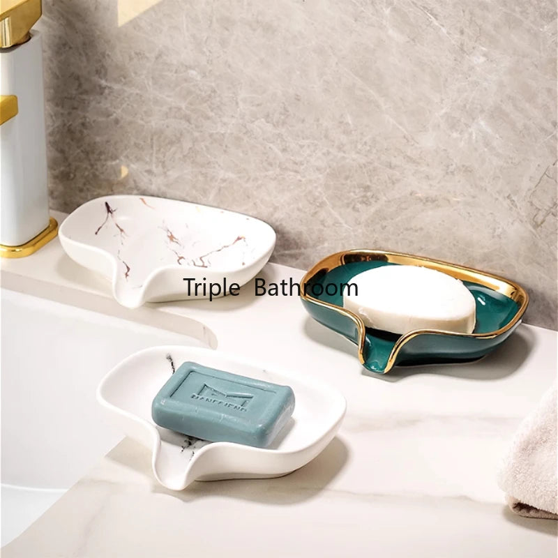 Trois porte-savons en céramique effet marbre avec grille de drainage, coloris blanc, vert et blanc, avec savons, sur un plan de vasque - Nesty
