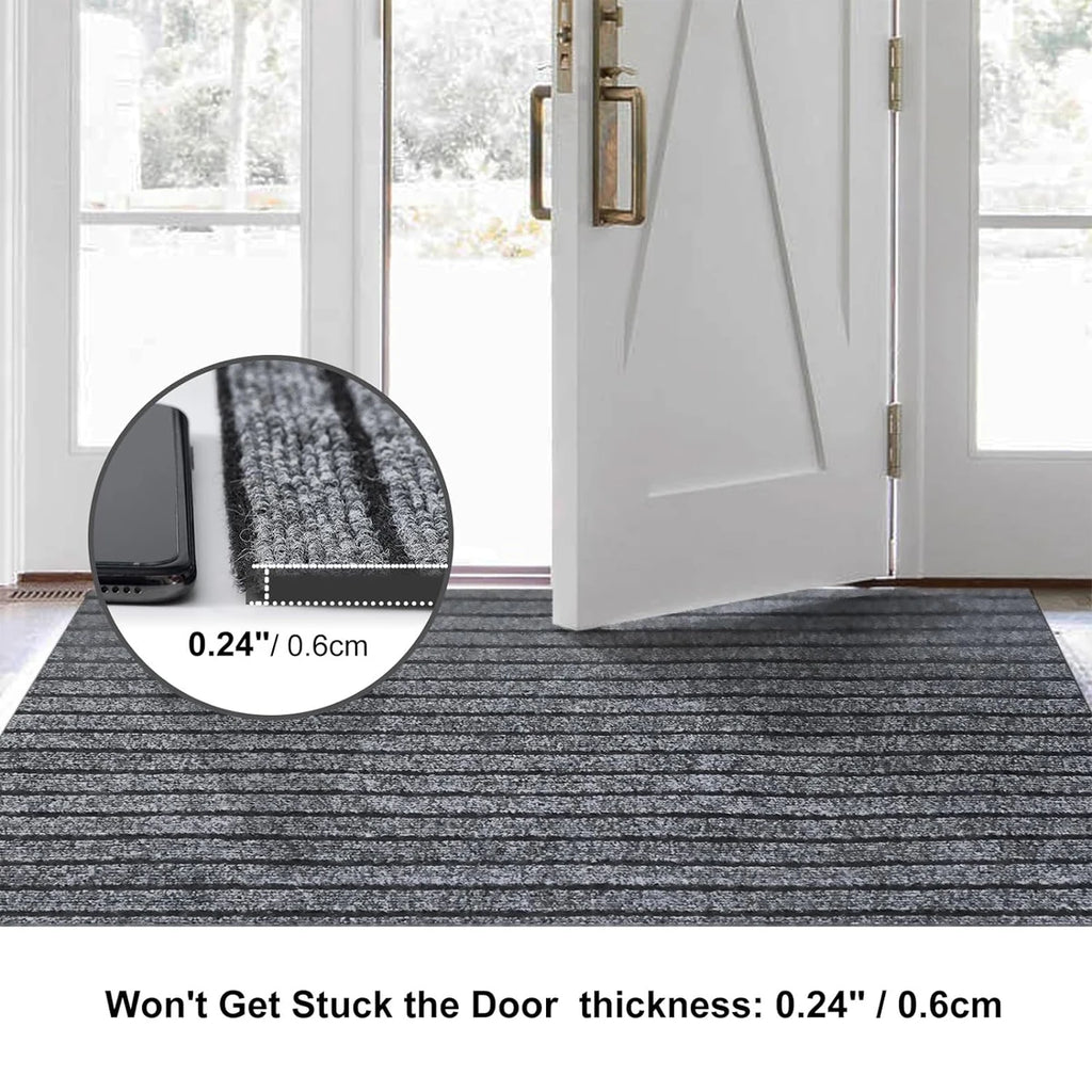 Tapis long à rayures — cuisine et entrée - Nesty, tapis gris à rayures posé devant une porte d'entrée ouverte, détail sur l'épaisseur de 0,6 cm