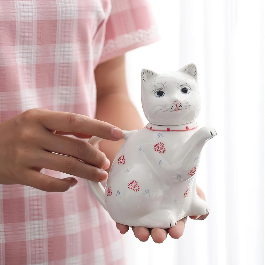 Théière en porcelaine forme de chat Nesty, tenue à deux mains, motifs floraux rouges et bleus visibles