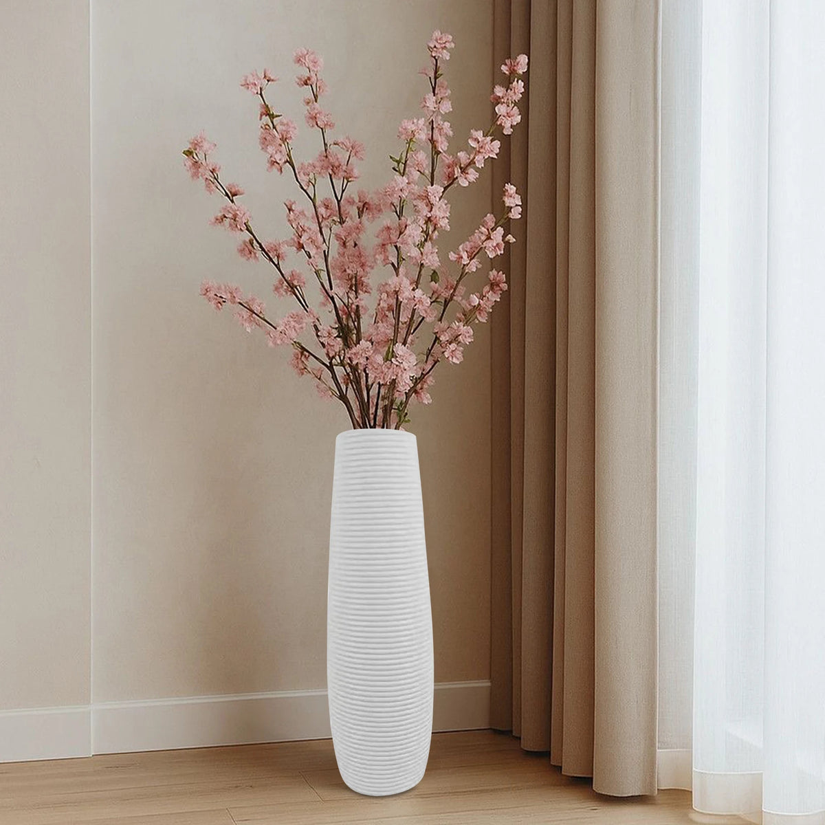 Vase décoratif à lignes texturées Nesty - Modèle blanc avec branches de fleurs de cerisier roses, dans une pièce beige