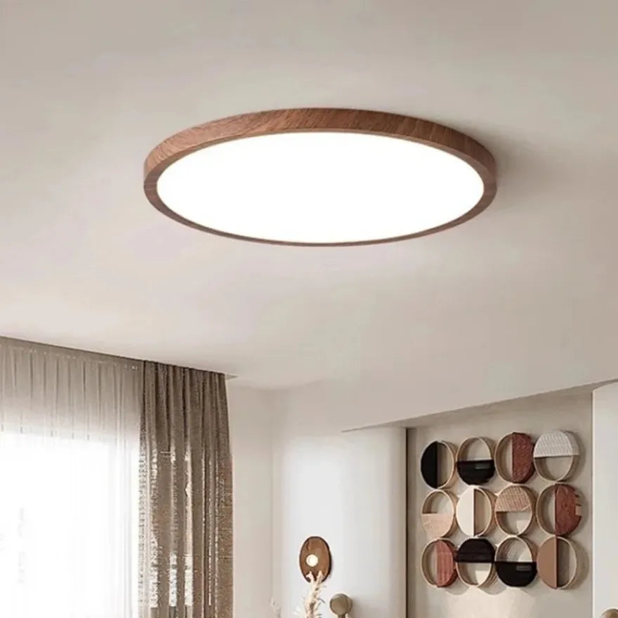 Plafonnier LED rond ultra-plat Nesty - Installé au plafond d'un salon avec rideaux beiges et décoration murale ronde