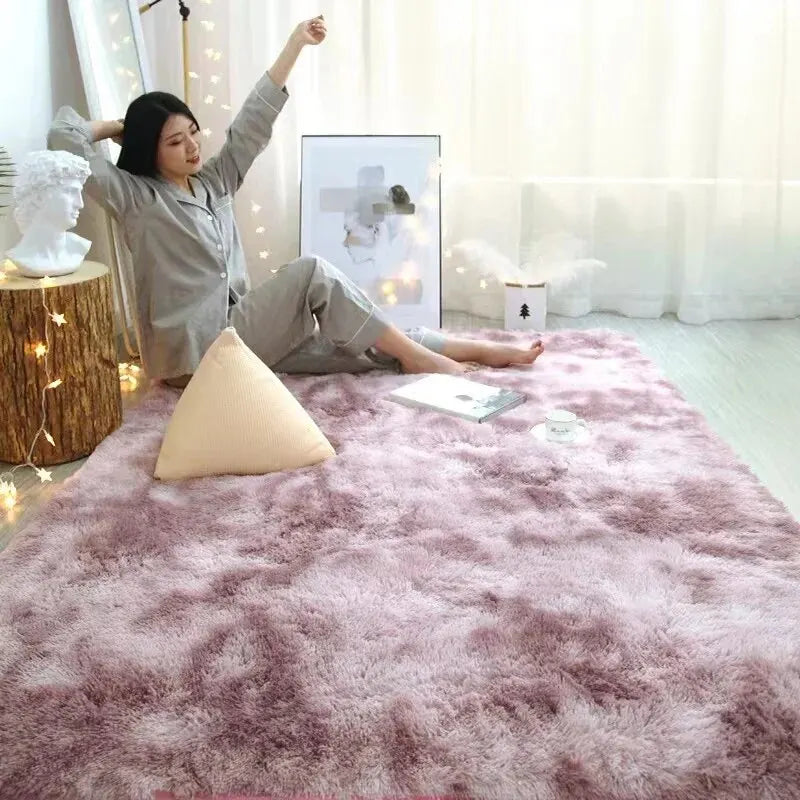 Petit tapis doux uni Nesty - Plusieurs tailles, coloris rose mauve chiné avec une personne assise dessus