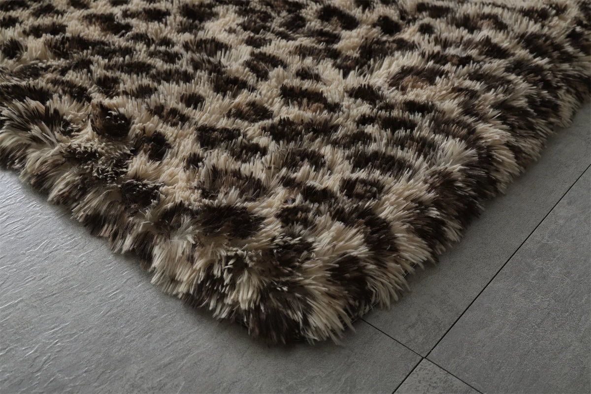 Tapis shaggy moelleux — plusieurs motifs - Nesty, gros plan sur un coin du tapis shaggy motif léopard posé au sol