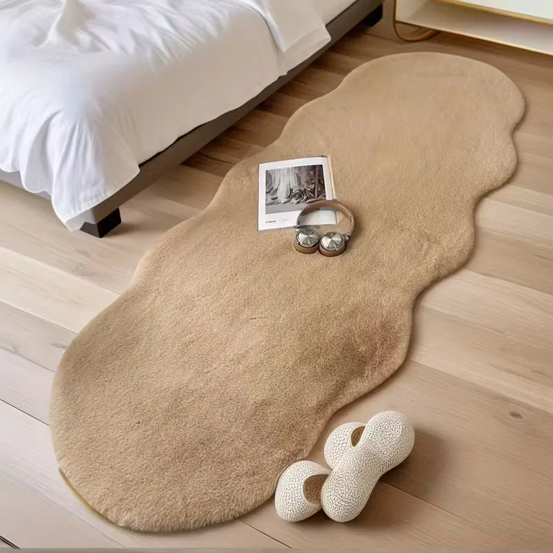 Tapis moelleux beige — pour chambre et bureau - Nesty, coloris beige camel en forme de nuage, au pied d'un lit avec des chaussons