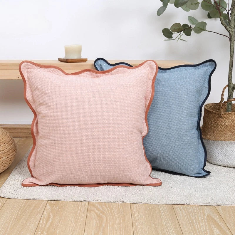 Housse de coussin en lin uni, bord ondulé, esprit bohème Nesty, housse rose corail et housse bleu ardoise à bord ondulé, posées côte à côte sur tapis moelleux
