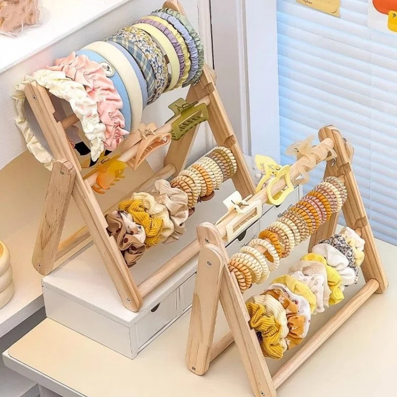 Présentoir en bois pour boucles d'oreilles et bijoux Nesty - Deux présentoirs avec bandeaux et chouchous tons pastel, près d'un store