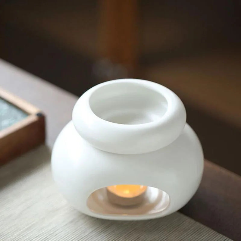 Brûle-parfum en céramique grande capacité Nesty - Modèle blanc avec vapeur, bougie allumée sur table basse