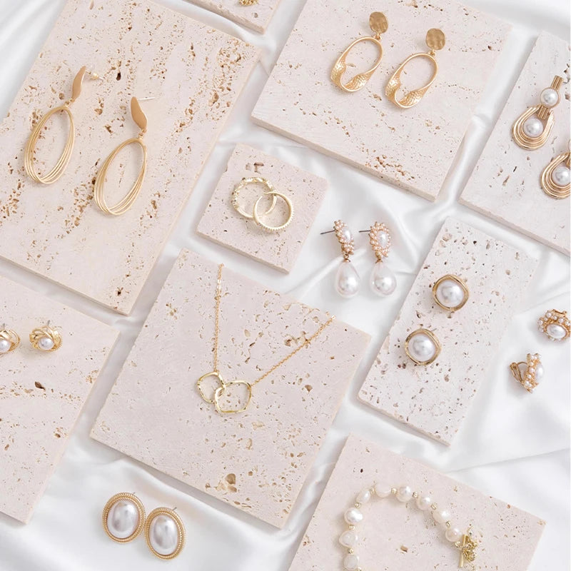 Vide-poche en travertin Nesty - Plusieurs plaques sur tissu blanc, avec boucles d'oreilles, bagues, collier et bracelet