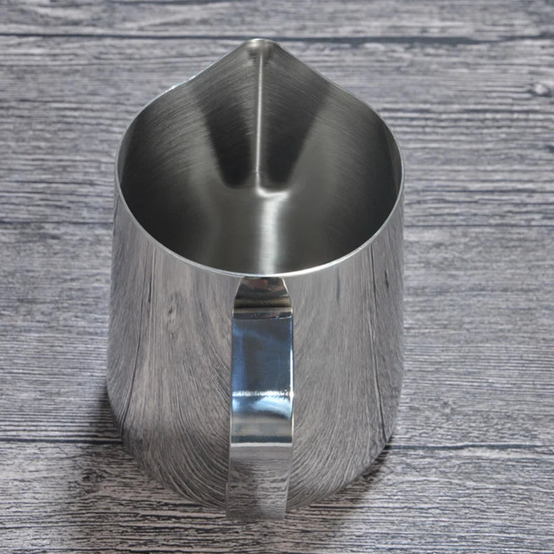 Pichet à lait en inox pour mousse et latte art Nesty, gros plan de dessus dans l'ouverture pointue, anse visible