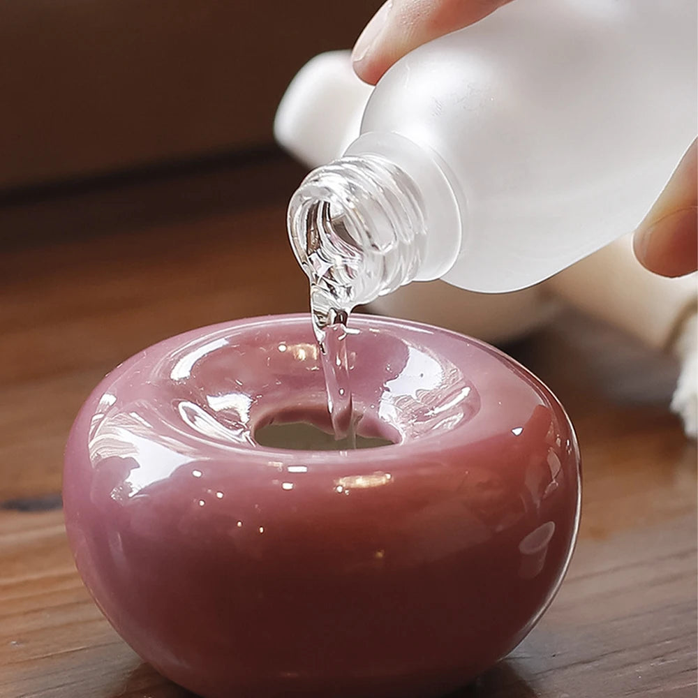 Diffuseur de parfum sans flamme forme animale Nesty - Remplissage du socle rose en forme de pomme avec le liquide parfumé