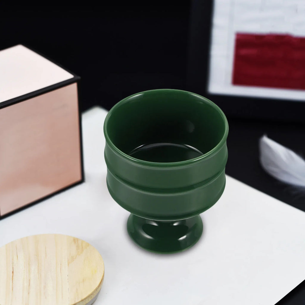 Plateau brûle-encens en céramique Nesty - Coupe évasée vert foncé vue de l'intérieur, posée sur un plateau en bois avec tissu rouge en arrière-plan