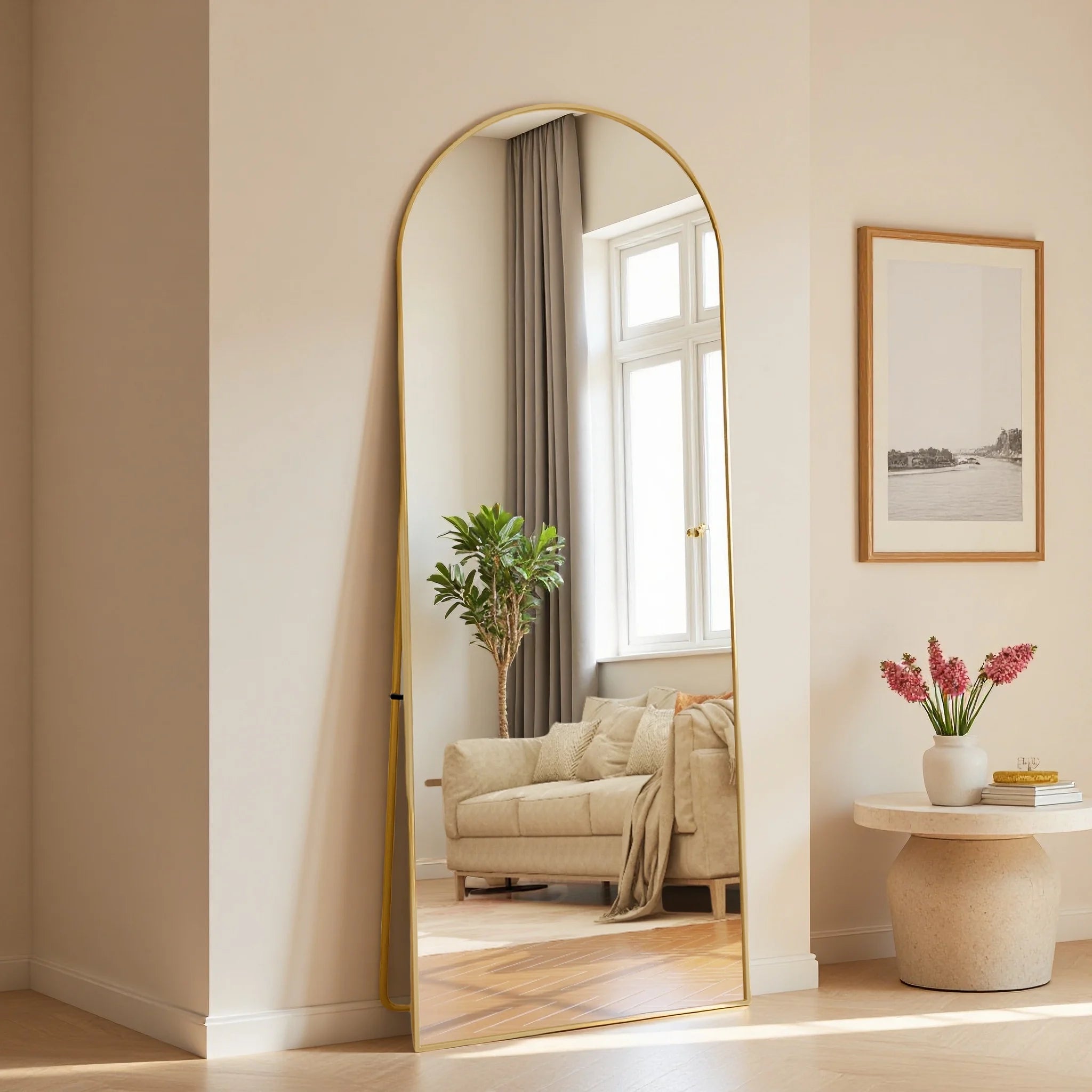 Miroir psyché incurvé Nesty - Cadre doré, reflet d'un salon avec rideau, plante et tableau encadré
