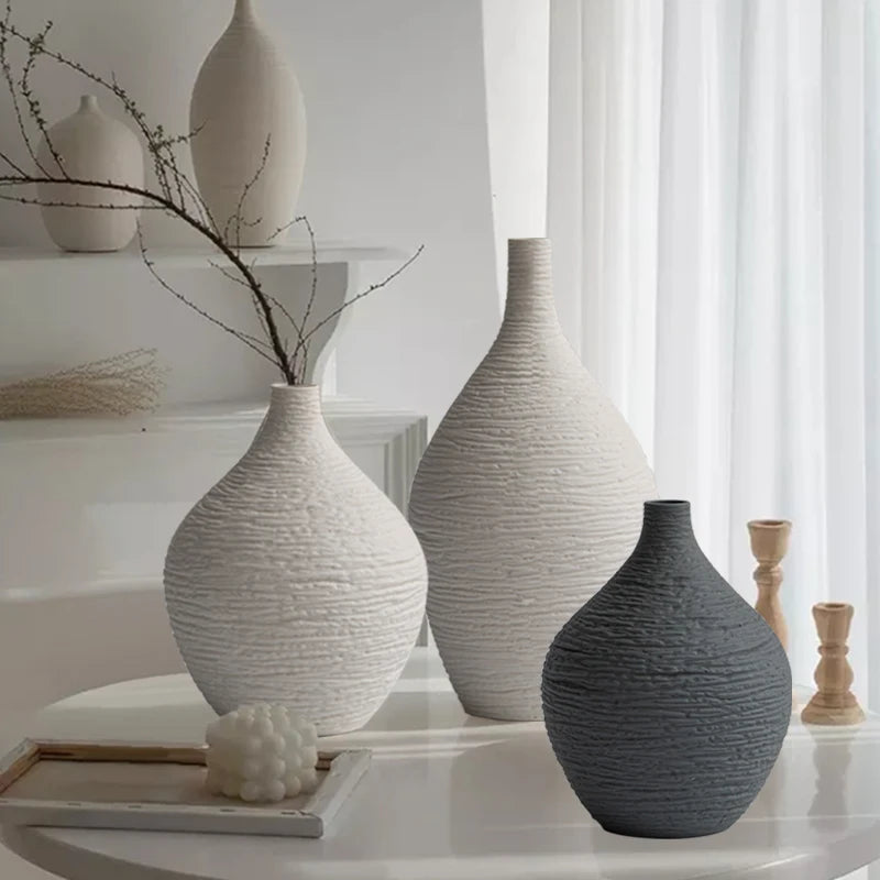 Vase en céramique à col étroit, style nordique sobre Nesty, trois vases en céramique texturée forme bouteille, coloris blanc cassé, écru et anthracite, tailles différentes, posés sur console avec bougeoirs en bois