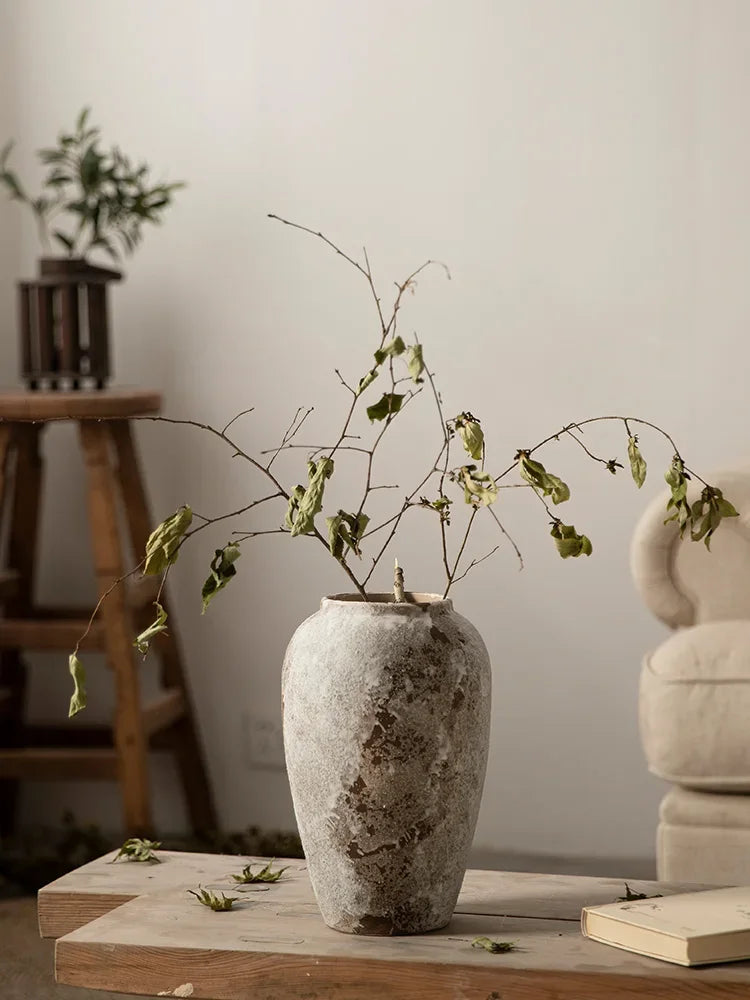 Vase en poterie mouchetée — esprit rétro chinois - Nesty - Grand format avec rameau de feuillage séché, sur tabouret devant un fauteuil beige