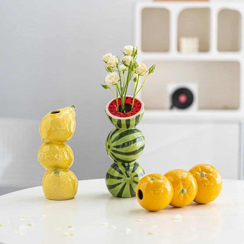 Coupelle-vase en céramique — fruits, fleurs ou bougie - Nesty - Trio de vases fruits devant un meuble beige, roses blanches dans le vase pastèque et mandarines posées à côté