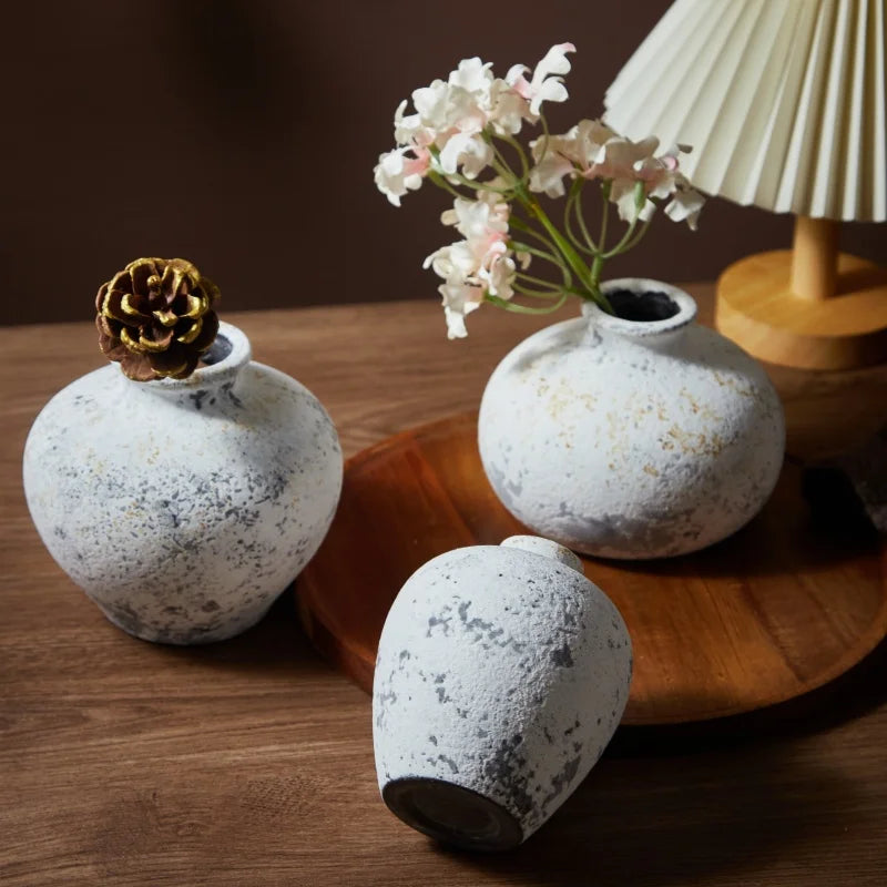 Vase en céramique fait main, esprit nostalgique Nesty, trois vases céramique effet pierre tacheté blanc et gris, tailles différentes, l'un garni d'une pomme de pin dorée, l'autre de fleurs blanches