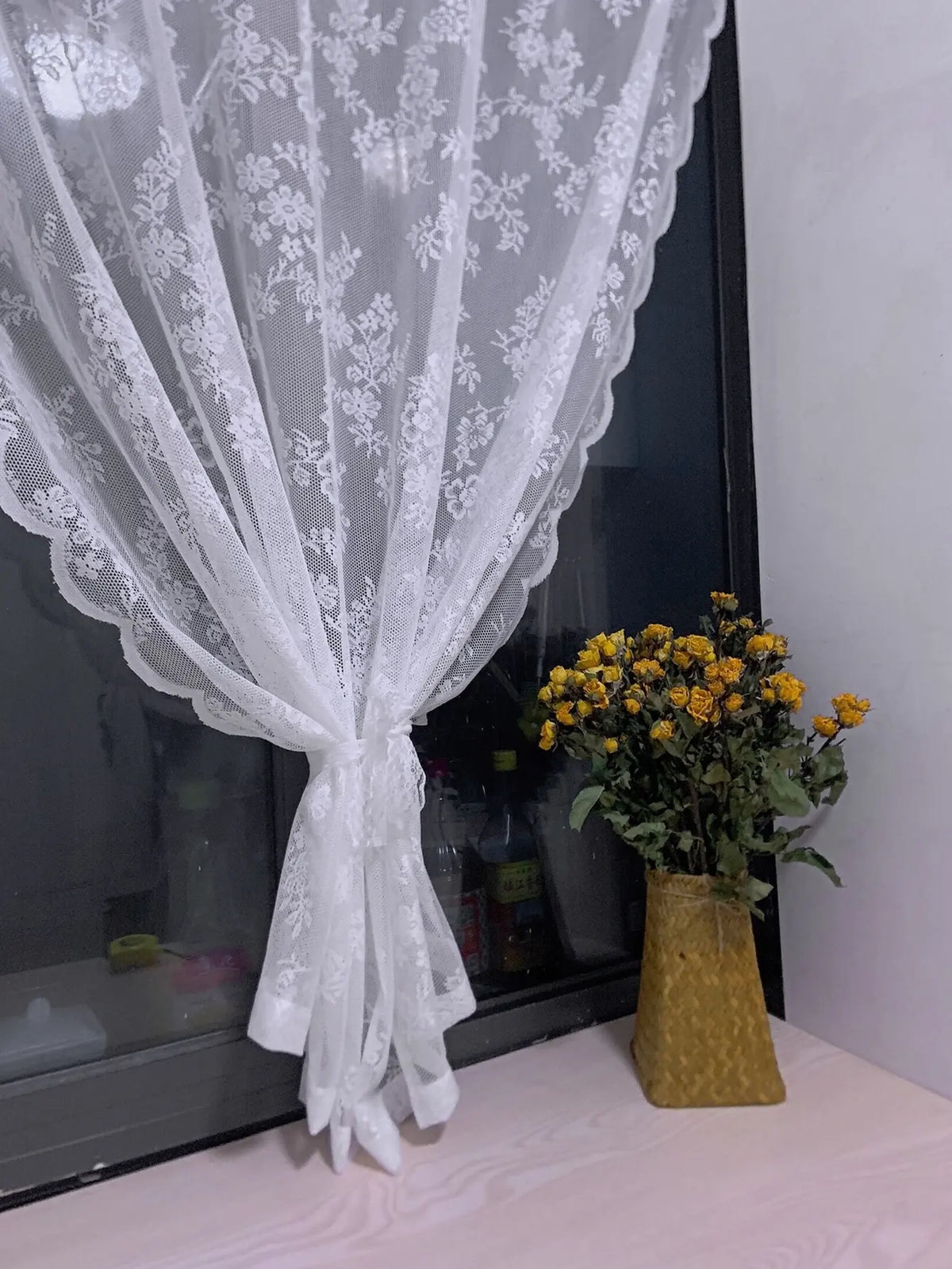 Voilage à motif dentelle florale Nesty - Pan de voilage noué près d'un bouquet de roses séchées jaunes