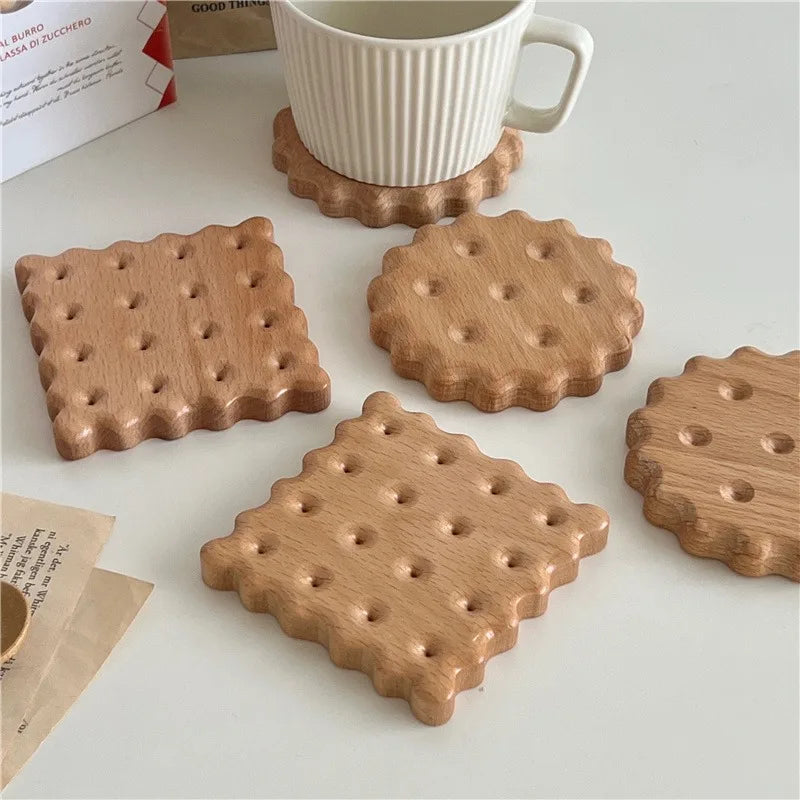 Dessous de verre en bois forme biscuit (carré et rond), tasse blanche cannelée posée dessus, sur une table blanche - Nesty